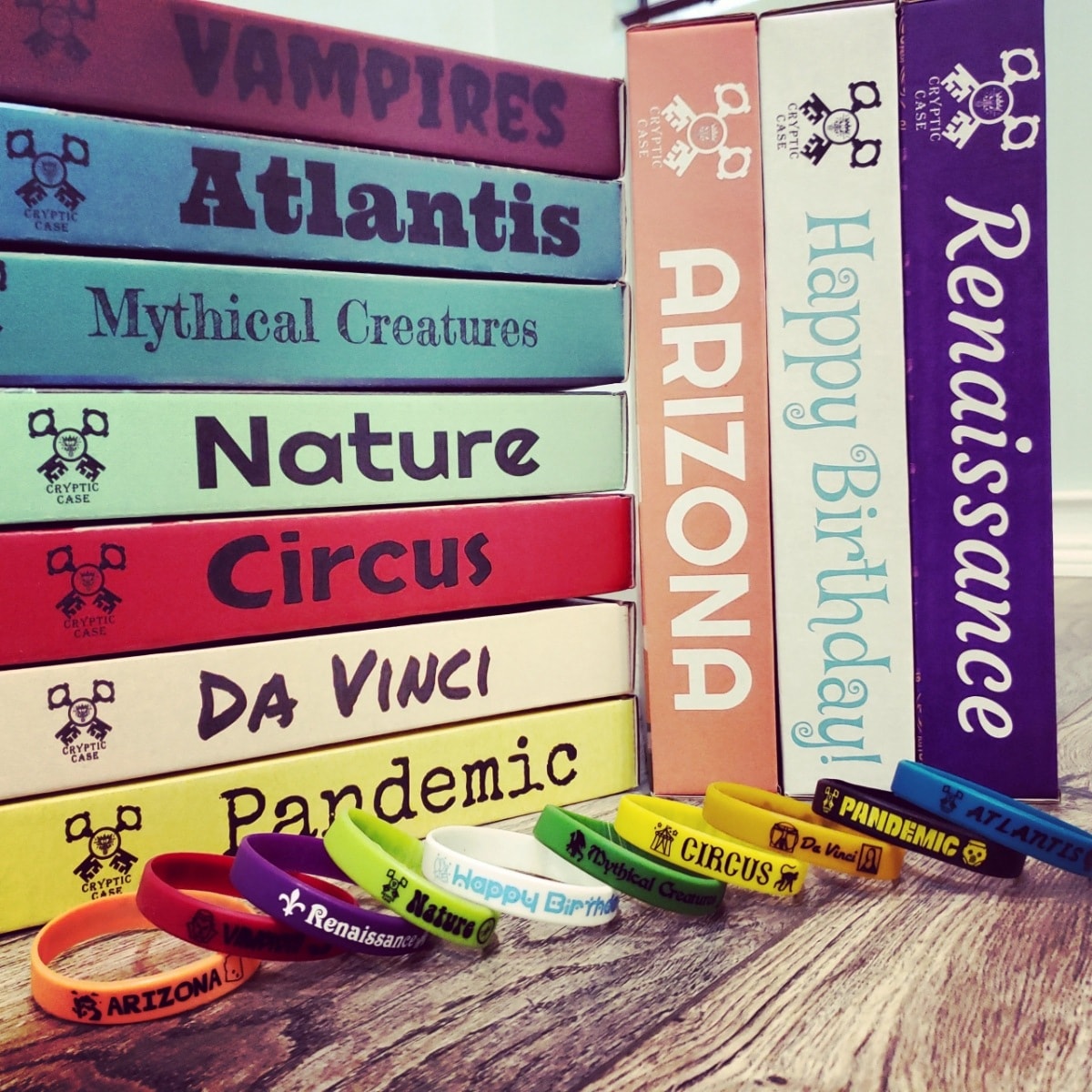 Colorful stack of Cryptic Case books with wristbands
